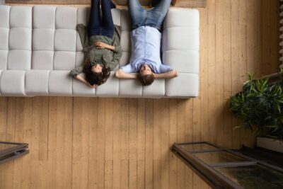 Couple put hands behind head relaxing on sofa